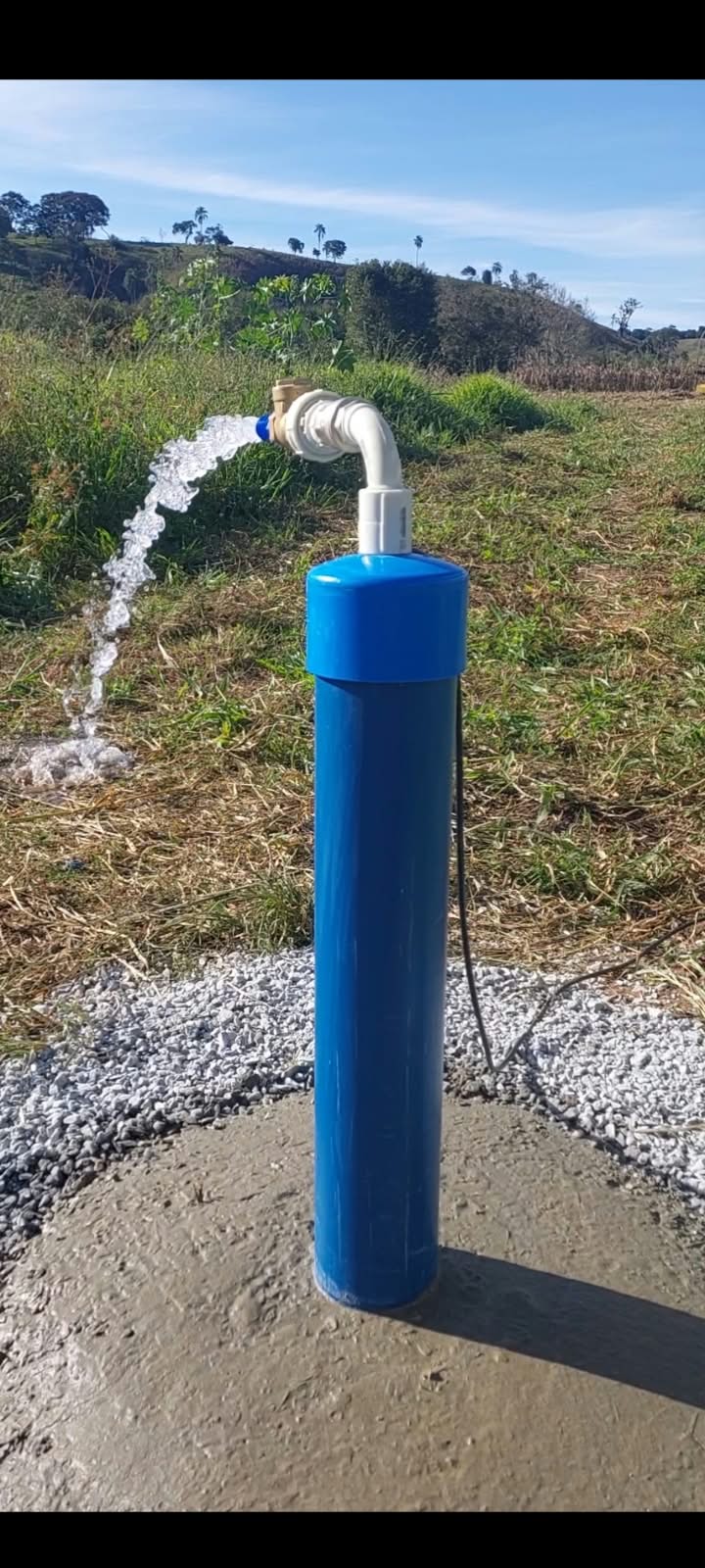 Poço semiartesiano finalizado fornecendo água limpa em propriedade rural